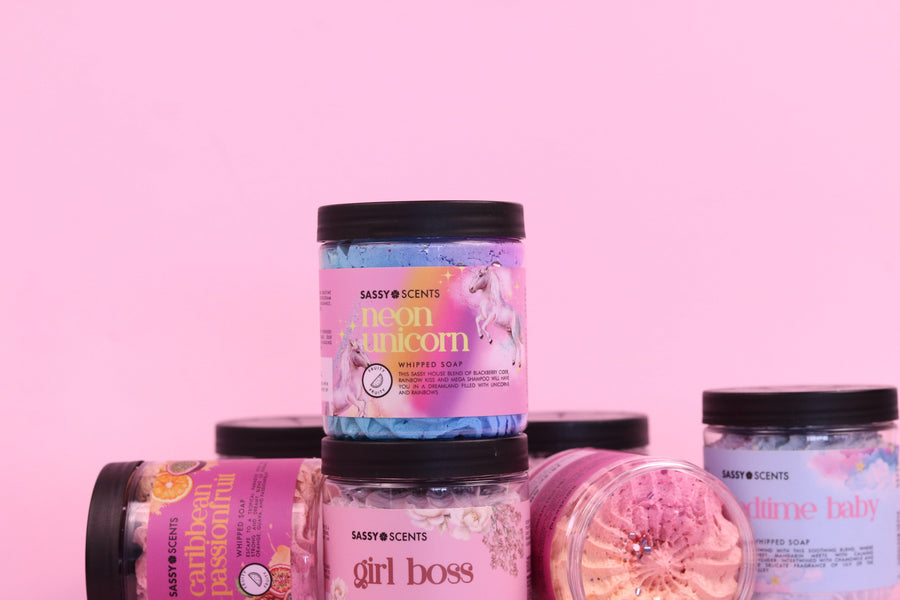 Collection of scented jars with colorful labels on a pink background
